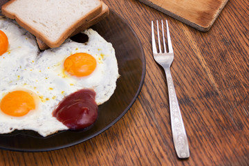 English breakfast, fried eggs with toast on an old textured table