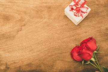 Flat lay image of Valentines Day Background with Gift Box and Red Rose on Wood Table Rustic style