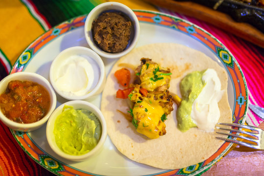 Plate of mexican chicken fajitas with dips