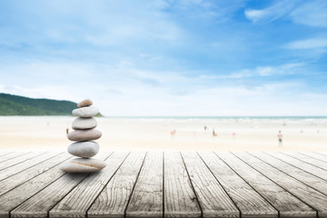 Stack of pebble stones  at the beach on a wooden surface. Concept Zen, Spa, Summer, Beach, Sea, Relax.