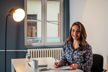 Modern business woman at office working with documents.