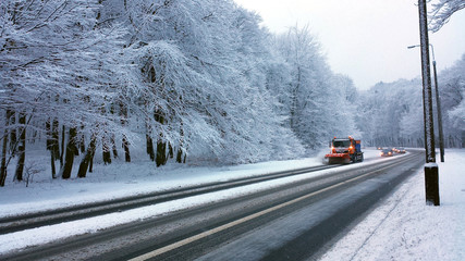 Gdynia, Poland - January 21, 2018: The snow plow clears the road in the snowy forest.