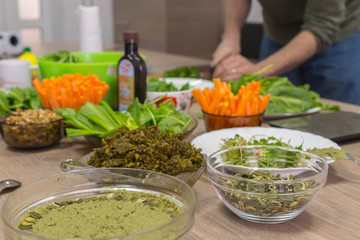 Cooking raw vegan spreads and sauces for a party with a variety of gluten free finger food and healthy snacks rich in vitamins
