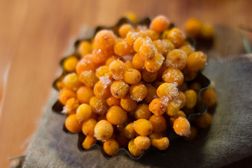 Fresh and ripe sea buckthorn berries in a metal bowl.