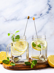 healthy eating, drinks, diet, detox . lemon water with mint in glass