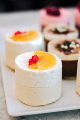 White cream cakes with fruits and berries in a restaraunt.