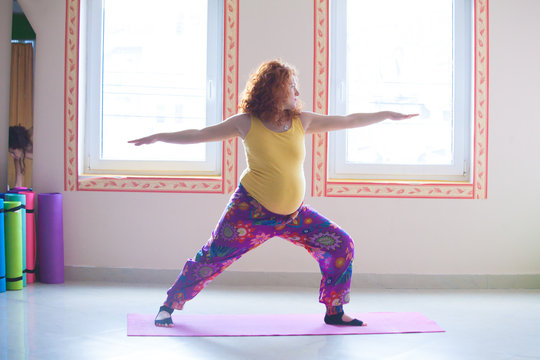 red head pregnant young woman practice yoga indoor
