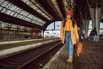 woman walk by railway station - obrazy, fototapety, plakaty