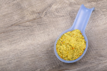 Spices in a spoon on a wooden background