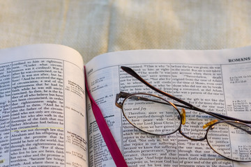 Glasses lay on Bible page with room for copy text