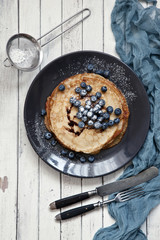 Traditional homemade pancakes. Celebration of Maslenitsa, Shrovetide. Top view, close-up on white rustic vintage wooden background