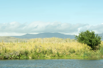 Landscape of mountain ranges and a stream.