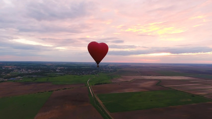 Hot air balloon shape of a heart in the blue sky. Aerostat, Airship. Red balloon.
