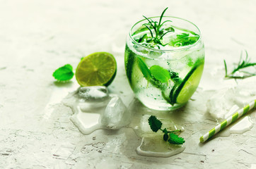 Homemade lime lemonade with cucumber, rosemary and ice, white background. Cold beverage, detox water. Copyspace. Banner