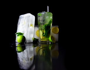 Cocktails in glass with ice cube isolated on black.
