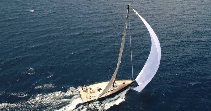 Aerial view of a sailing boat navigating with open sails.