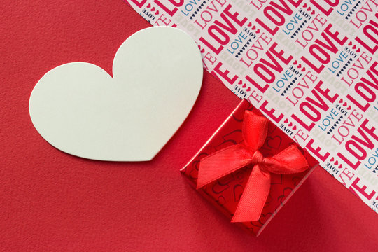 Valentines day backround red gify box with ribbon red background and lettering Love.