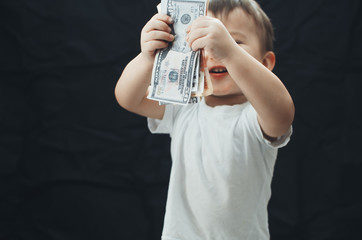 the child with the money in hand on black background