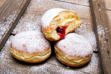 Traditional Polish donuts on wooden background. Tasty doughnuts with jam.
