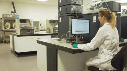 Scientists in the laboratory in front of computers do scientific research. Female researcher working on a computer in a laboratory.