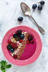Smoothie bowl with red beets, berries and flax seeds.