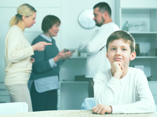 Unhappy boy during parents and grandma quarreling