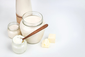 Bottle with milk and a can of sour cream isolated on white background