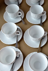 Empty white cups and saucers are on the table. Close-up. The view from the top. Vertical orientation