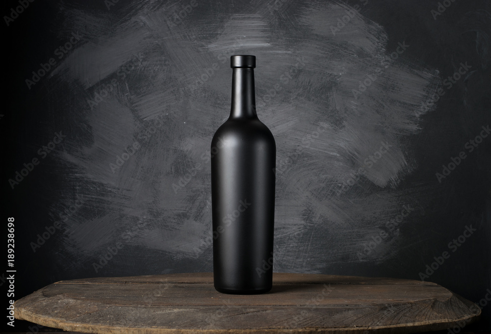 Wall mural red wine bottle on a wooden background