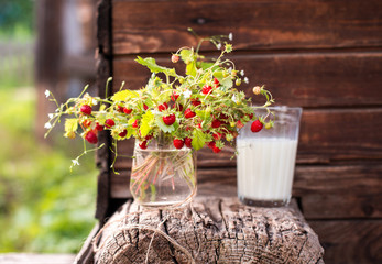 Berry bouquet in a glass on a wooden background