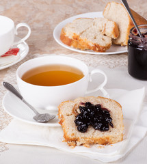 Slice of Sweet Bread Spread with Blueberry Preserves and Cup of Tea
