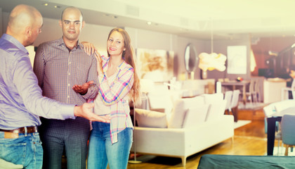 Couple choosing furniture in salon