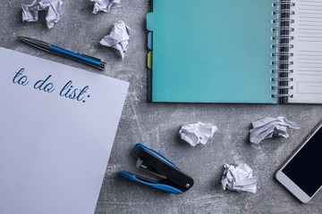 Wheeled notebook, smartphone, blue paper stapler, blue elegant pen and white paper and a piece of...