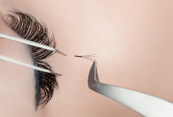 Fototapeta premium Eyelash extension procedure close up. Beautiful Woman with long lashes in a beauty salon.