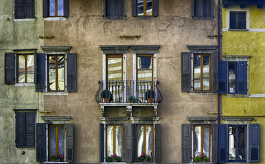A colorful traditional italian facade with old blinds and reflections, Udine. Italian antique...