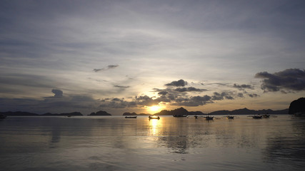 Marine tropical sunset over the sea. Sunset over the sea in the background boats, orange sky and islands. Travel concept. Nothing but sky, clouds and water. Beautiful serene scene.