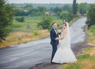 Elegant bride and groom posing together outdoors