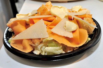 Detail of a salmon cooked plate decorated by a chef with pineapple, cheese shavings and balsamic glaze.