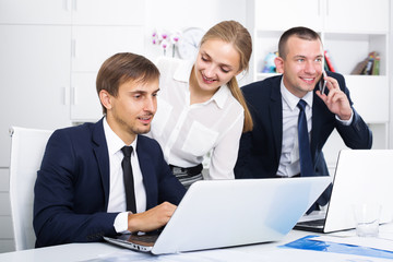 Smiling coworkers working and talking on phone