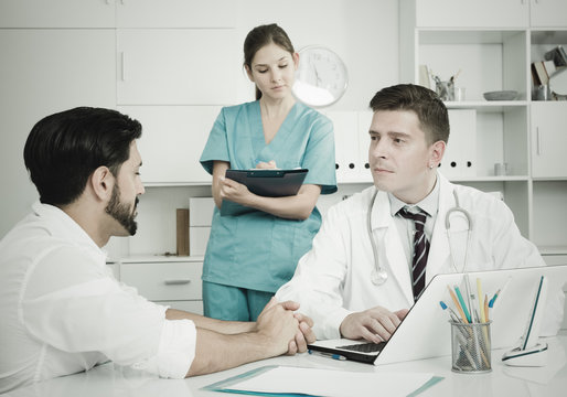Doctor and assistant with patient in medical office