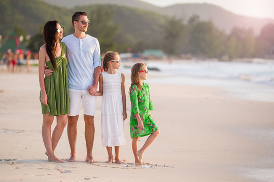 Happy Family With Kids Walk On The Beach