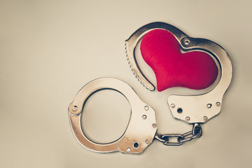 Handcuffs with a red love heart with copy space to add text