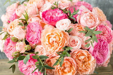 beautiful bouquet of mixed flowers in a box on wooden table. the work of the florist at a flower shop
