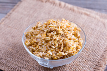 Granola in a glass bowl on a wooden table