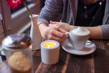 closeup of woman sitting at cafe with cup of coffee