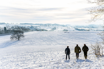 Three Men Walking in Snowy English Countryside