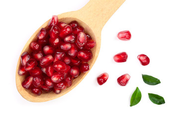 pomegranate seeds in wooden spoon with leaves isolated on white background. Top view. Flat lay pattern