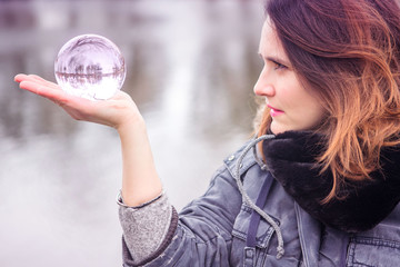 closeup of young woman holding a glass sphere