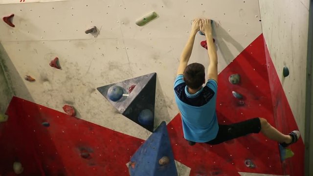 A rock climber climbs a steep wall and breaks down after a failed attempt to climb to the top.