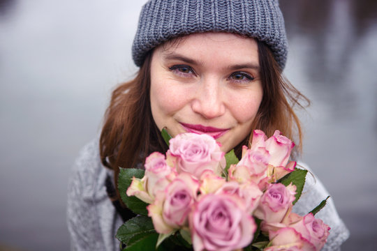 Young Woman Outdoors With Bouquet Of Pink Roses